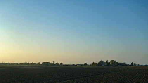 Scenic view of field against clear sky during sunset