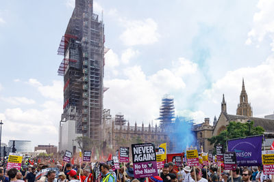 Group of people in front of buildings against sky