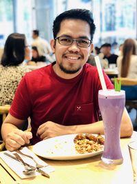 Portrait of young man sitting at restaurant table