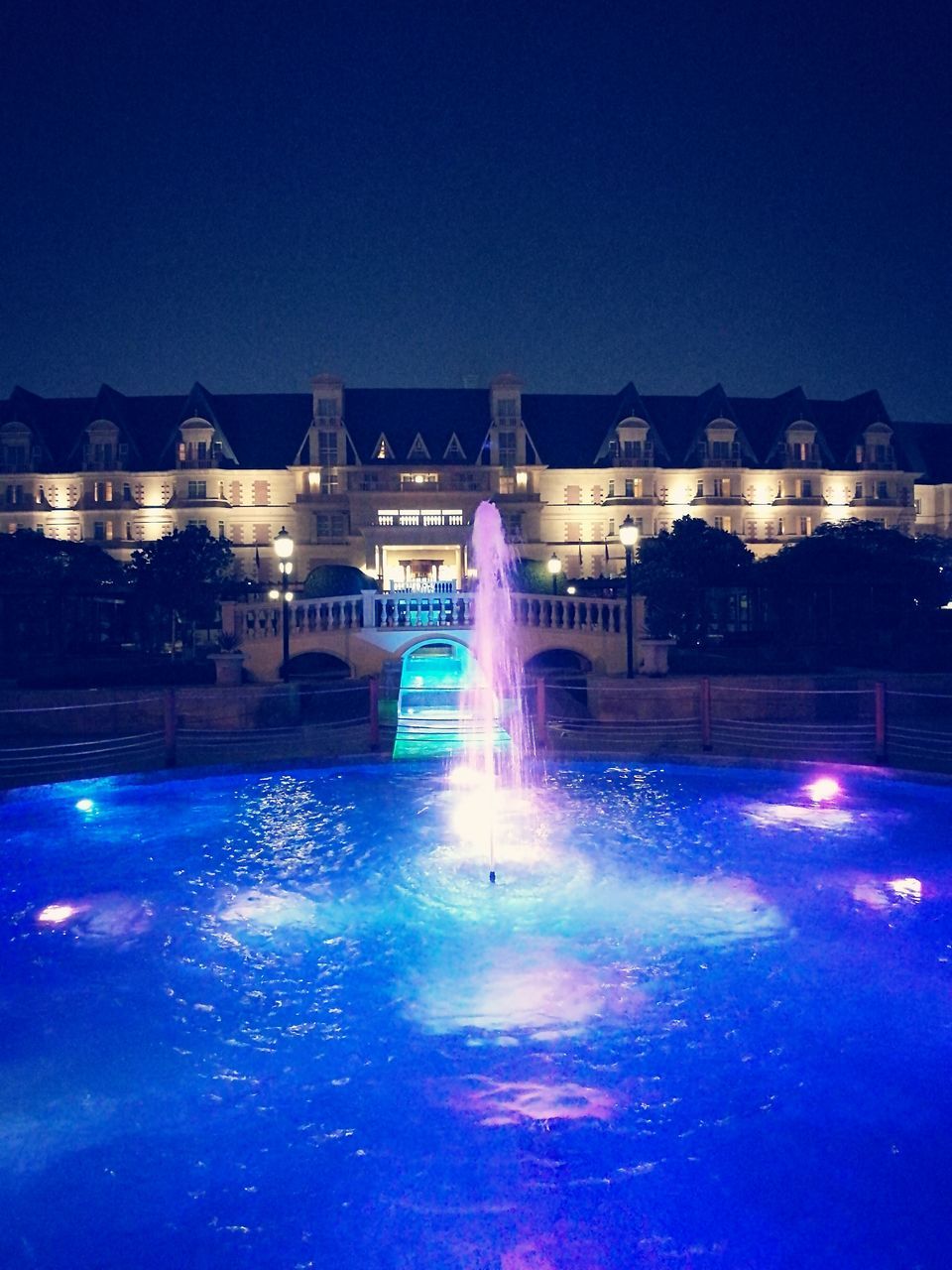 water, swimming pool, splashing, built structure, building exterior, architecture, night, waterfront, motion, sky, no people, illuminated, fountain, outdoors, water park, swimming lane marker