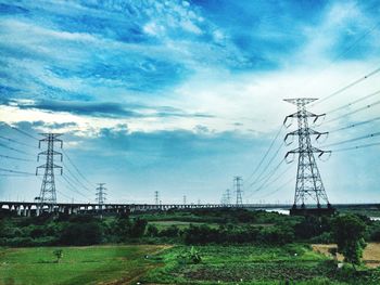 Electricity pylon on field against sky