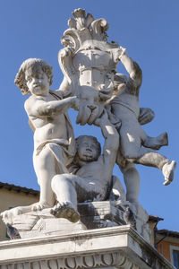 Low angle view of statue against building against sky