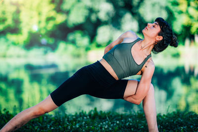 Yoga woman by the water. twisted side angle