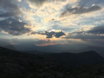 Scenic view of silhouette mountains against dramatic sky