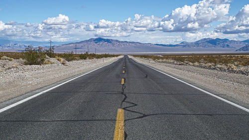 Empty road with mountain range in background