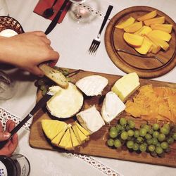 Close-up of hand holding fruits on table