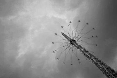 Low angle view of high carousel against sky