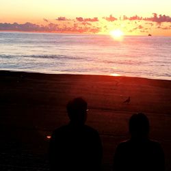 Silhouette of men at beach during sunset