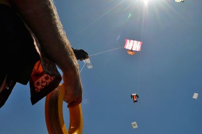 Midsection of man flying kite against sky