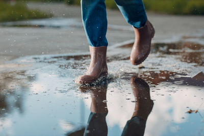 Low section of man with reflection in puddle