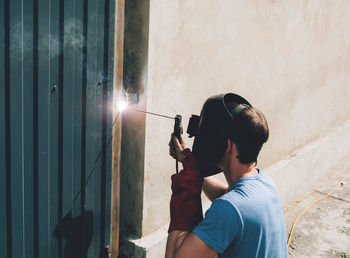 A man works in a protective mask with metal welding. hand work concept, industry and construction