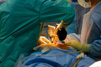 Midsection of surgeons operating patient