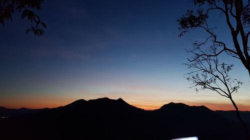 Scenic view of silhouette mountains against sky at sunset