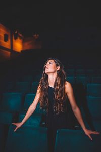 Beautiful young woman looking away while standing in room