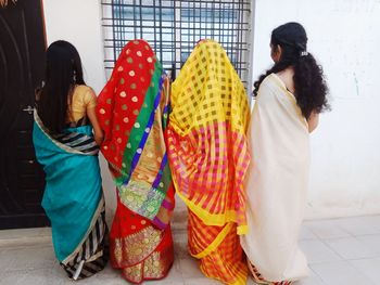 Rear view of women standing on floor