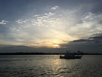 Silhouette ship sailing on sea against sky during sunset