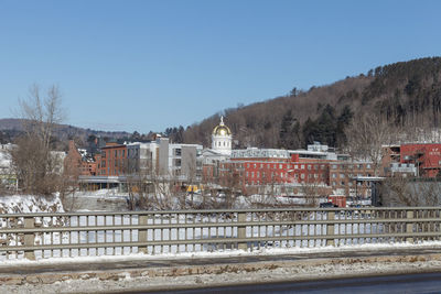 Buildings against clear blue sky during winter