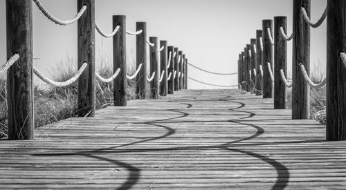 View of wooden footbridge against clear sky