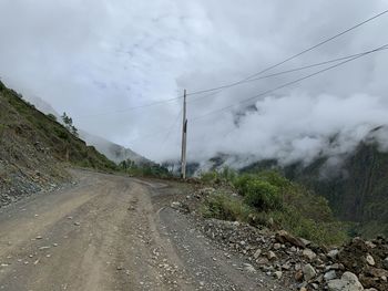 Road by mountain against sky