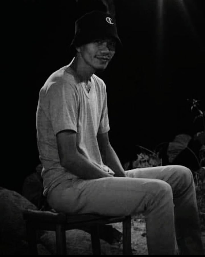 sitting, black and white, one person, monochrome photography, black, adult, monochrome, darkness, men, indoors, hat, casual clothing, seat, person, performance art, musician, cap, emotion, three quarter length, clothing, lifestyles