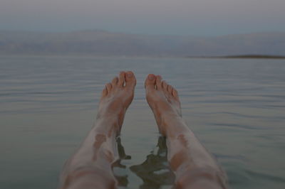 Low section of man relaxing in sea