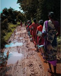 Rear view of people walking by water