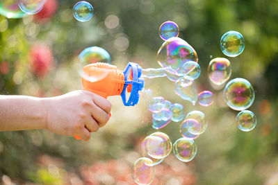 Cropped hand playing with bubble wand