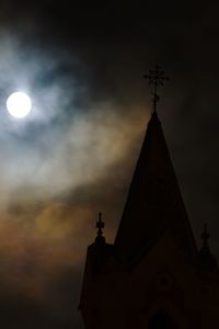 Low angle view of weather vane against sky