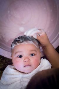 High angle view of mother bathing baby in bathroom at home