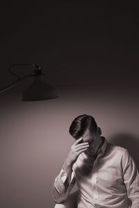 Depressed young man sitting indoors