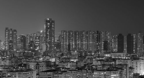 Illuminated buildings in city against sky at night