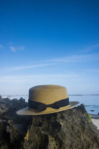 Scenic view of rocks on beach against blue sky