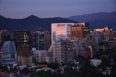 Buildings in city against sky at dusk