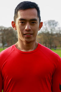 Portrait of young man standing against sky