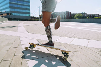 Woman longboarding on footpath