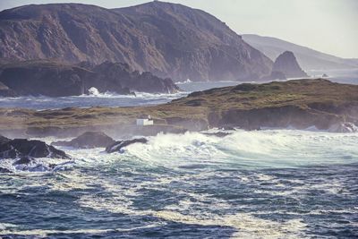 Scenic view of sea and mountains against sky