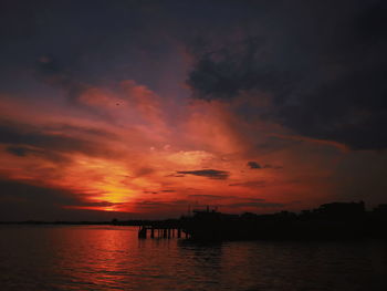 Scenic view of sea against dramatic sky during sunset