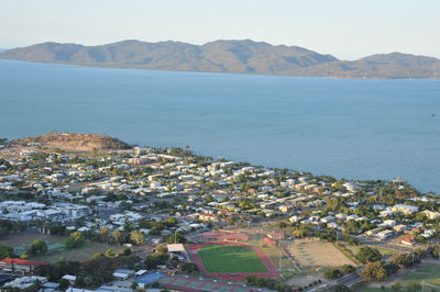 Aerial view of city by sea against sky