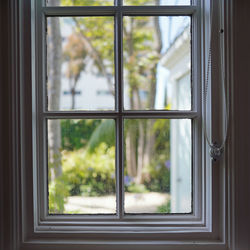 Trees seen through window of house