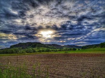 Scenic view of field against cloudy sky