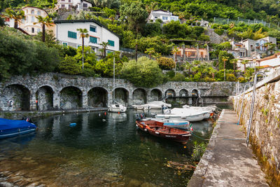 Arch bridge over river amidst buildings in city