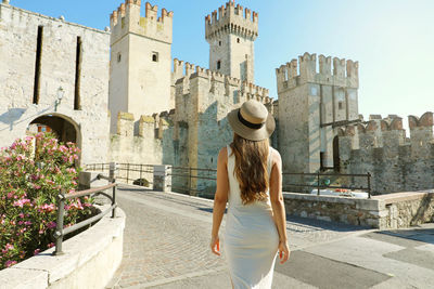 Rear view of woman with umbrella against buildings in city
