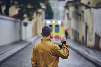 Rear view of man using smart phone on street