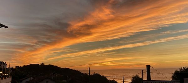 Scenic view of dramatic sky over sea during sunset
