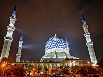 Illuminated temple building against sky at night