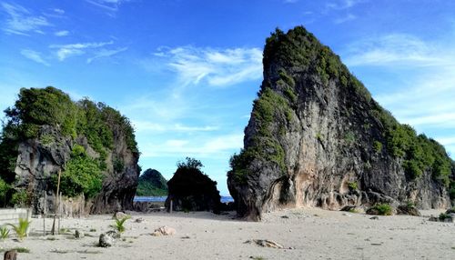 Panoramic view of rocks on beach against sky