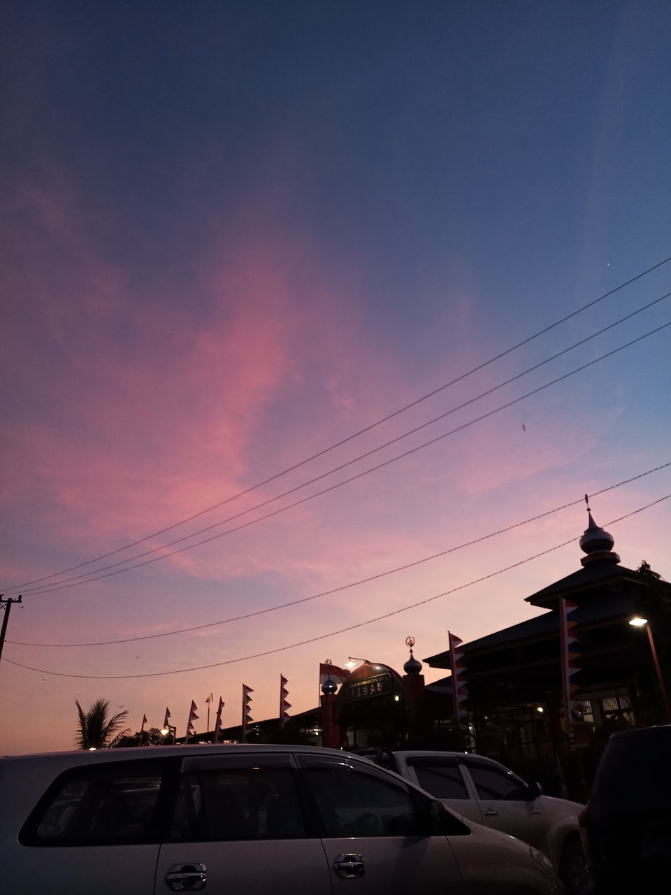 CARS ON STREET AGAINST SKY AT DUSK