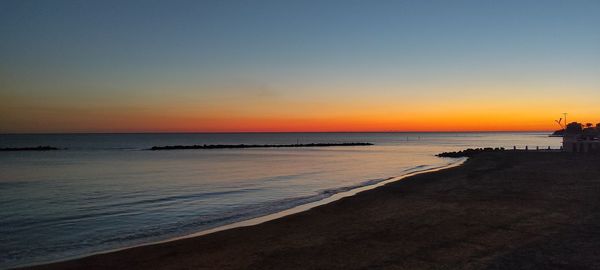 Scenic view of sea against clear sky during sunset