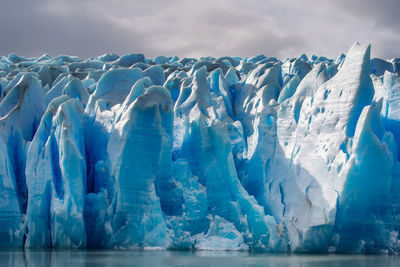 Icebergs in sea against sky