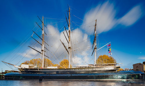 Sailboats moored in sea against blue sky